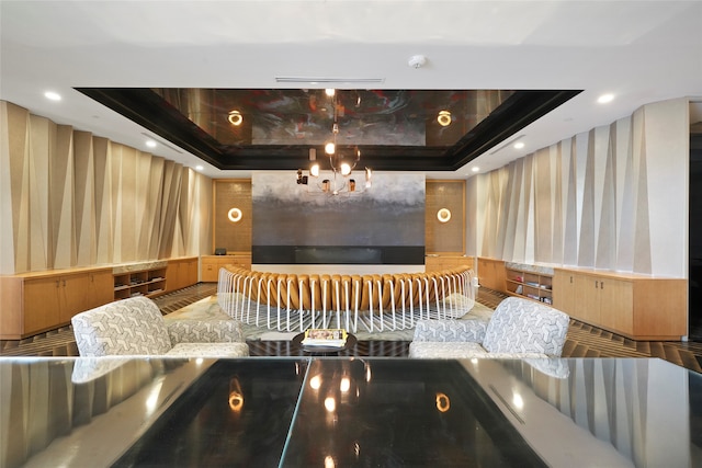 cinema room featuring a chandelier and a tray ceiling