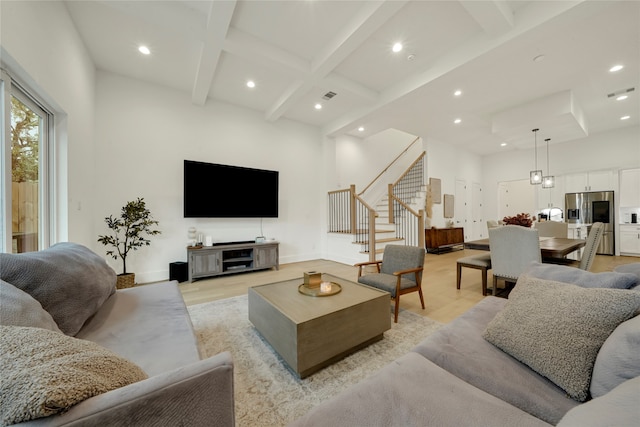 living room featuring light wood-type flooring, a high ceiling, beam ceiling, and coffered ceiling