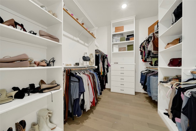 walk in closet with light hardwood / wood-style flooring