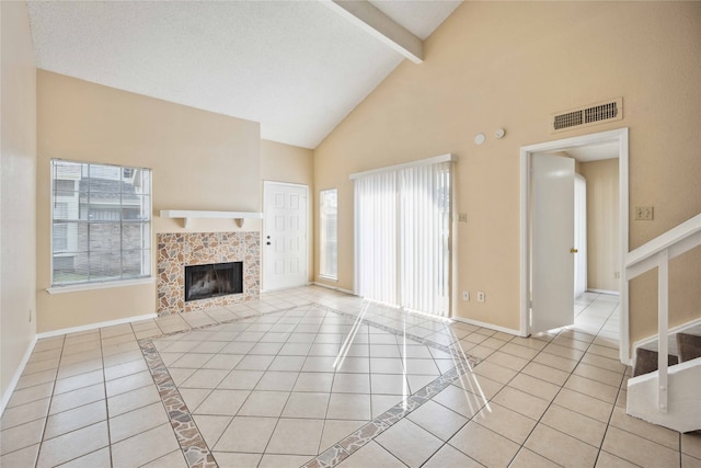 unfurnished living room featuring a tiled fireplace, beam ceiling, light tile patterned flooring, a textured ceiling, and high vaulted ceiling