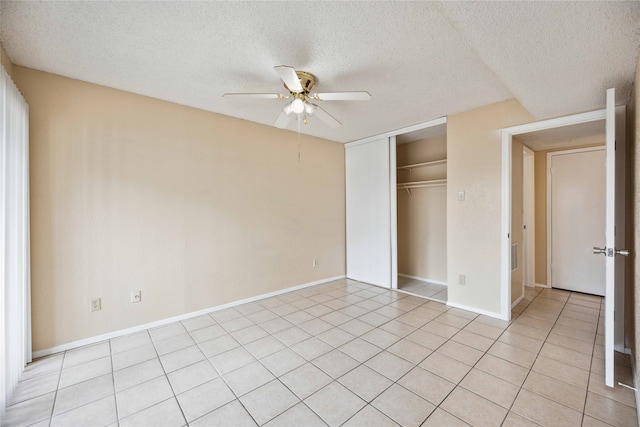 unfurnished bedroom with a closet, a textured ceiling, light tile patterned floors, and ceiling fan