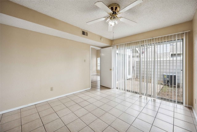 empty room featuring a textured ceiling, ceiling fan, and light tile patterned floors