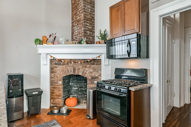 kitchen with black appliances and dark hardwood / wood-style flooring