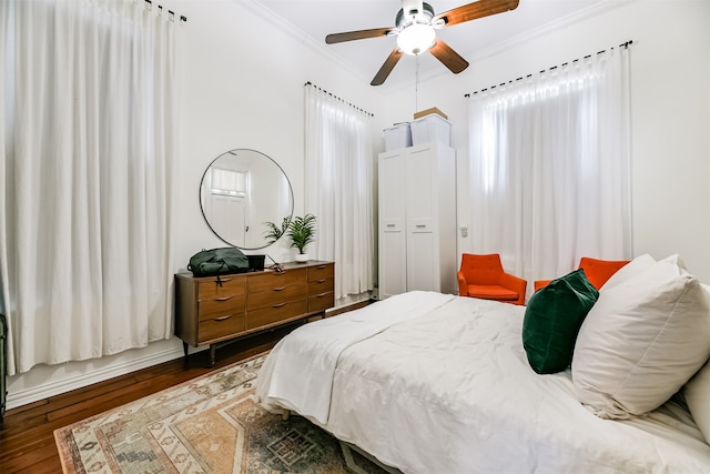 bedroom with ceiling fan, crown molding, dark hardwood / wood-style flooring, and multiple windows