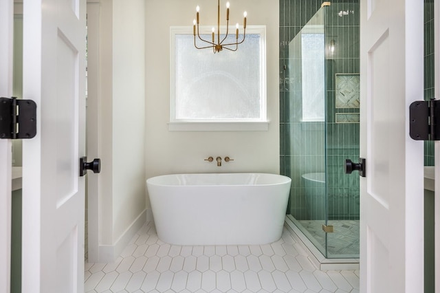 bathroom with an inviting chandelier, separate shower and tub, and tile patterned flooring