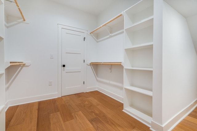 walk in closet with light hardwood / wood-style floors