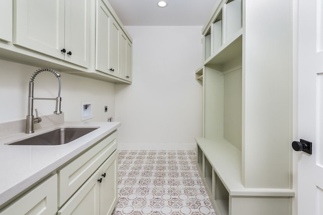 clothes washing area with washer hookup, electric dryer hookup, cabinets, and sink