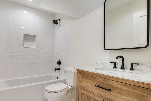 full bathroom with tiled shower / bath, vanity, and toilet