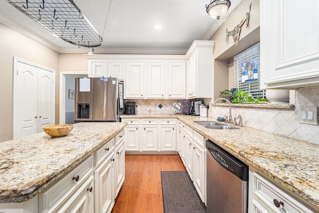 kitchen with white cabinets, appliances with stainless steel finishes, light hardwood / wood-style floors, and ornamental molding