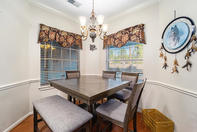 dining room featuring a chandelier, crown molding, and dark wood-type flooring