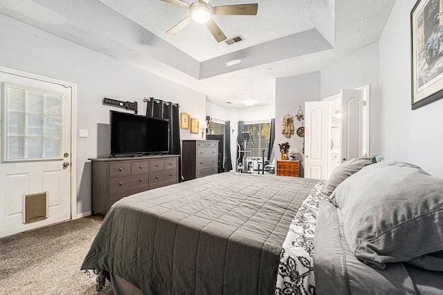 bedroom featuring carpet flooring, ceiling fan, a tray ceiling, and a textured ceiling