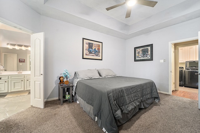 bedroom with ceiling fan, light colored carpet, ensuite bathroom, and sink