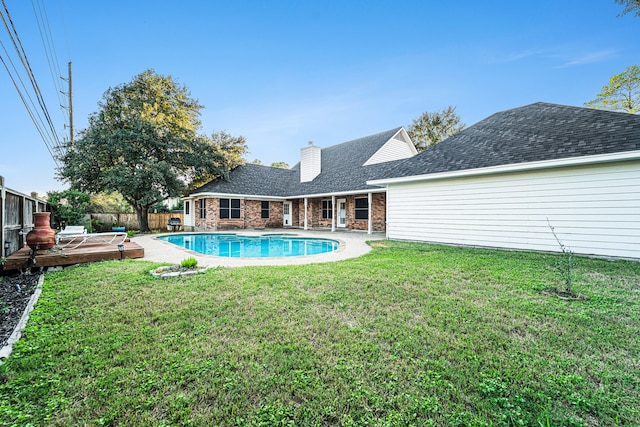 view of swimming pool with a wooden deck and a yard