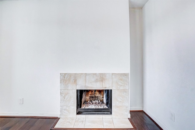 room details with a tiled fireplace and hardwood / wood-style floors