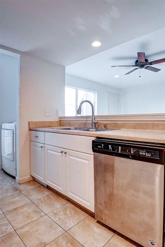 kitchen featuring white cabinets, sink, stainless steel dishwasher, ceiling fan, and washer / clothes dryer