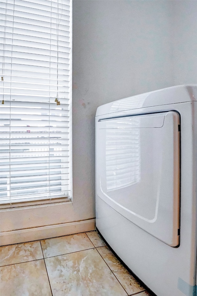 clothes washing area featuring washer / clothes dryer and light tile patterned floors