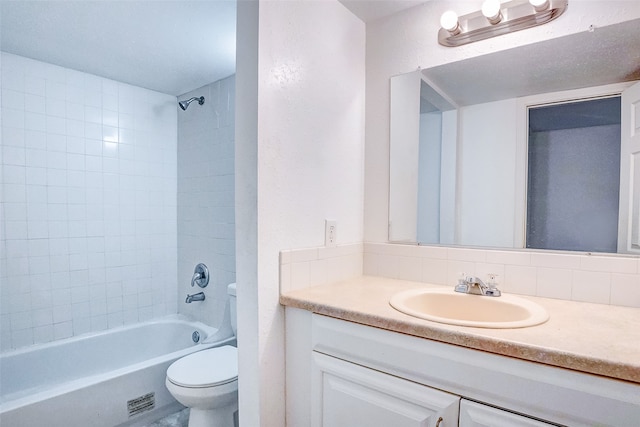 full bathroom with vanity, tiled shower / bath combo, toilet, and backsplash