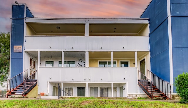 back house at dusk with a balcony