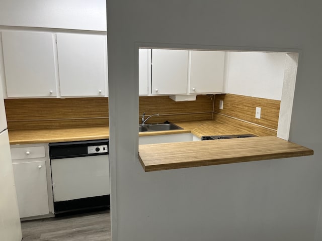 kitchen featuring sink, dishwasher, white cabinets, decorative backsplash, and light hardwood / wood-style flooring