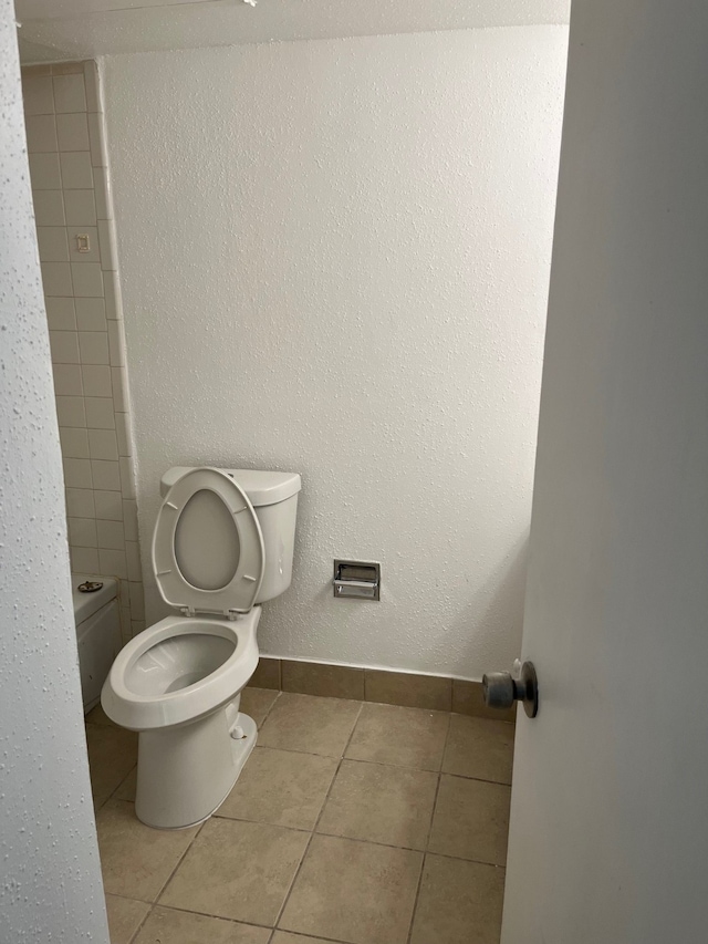 bathroom with toilet and tile patterned flooring