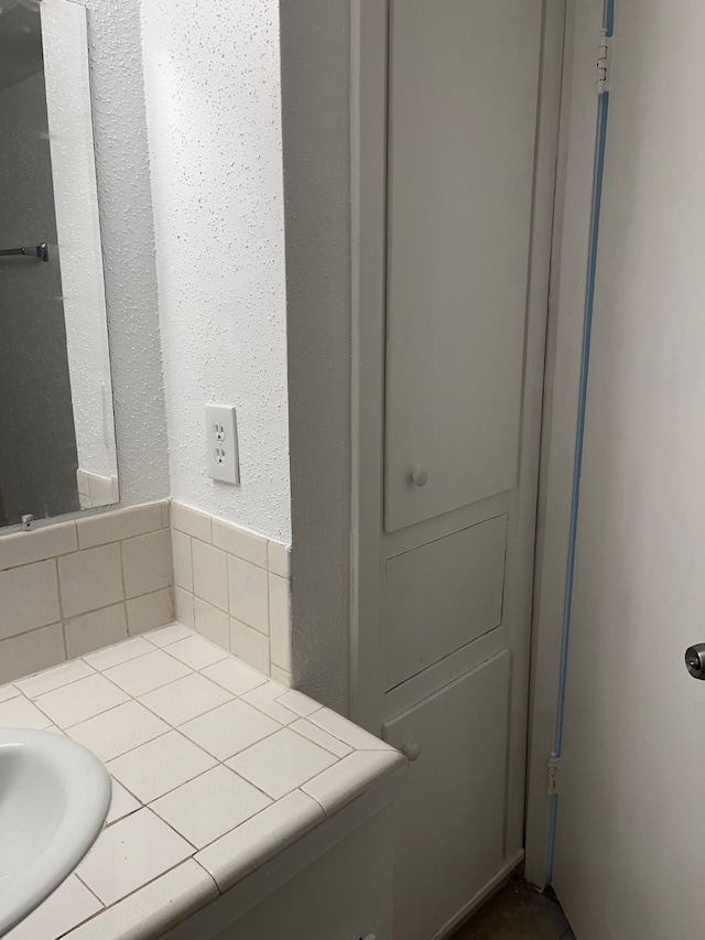 bathroom featuring vanity and tasteful backsplash