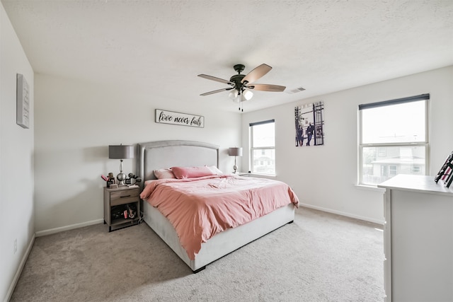 carpeted bedroom with ceiling fan and a textured ceiling