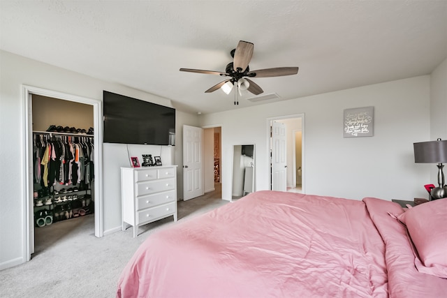 carpeted bedroom featuring a closet, a spacious closet, and ceiling fan