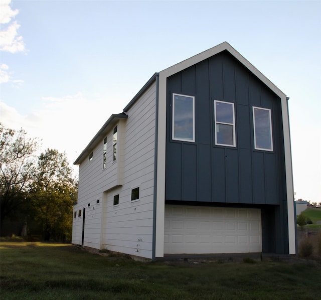 view of side of home featuring a garage and a lawn