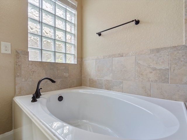 bathroom featuring a wealth of natural light and a bath