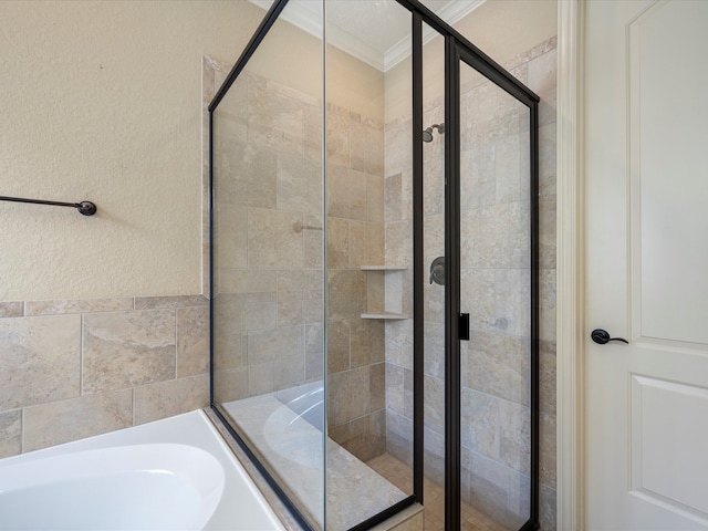 bathroom featuring ornamental molding and separate shower and tub