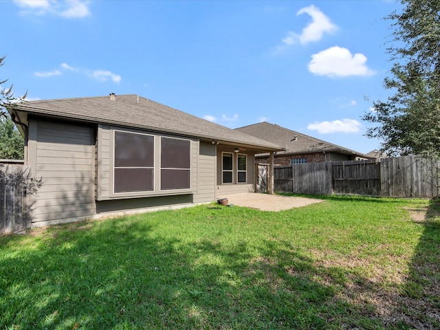 rear view of property with a lawn and a patio