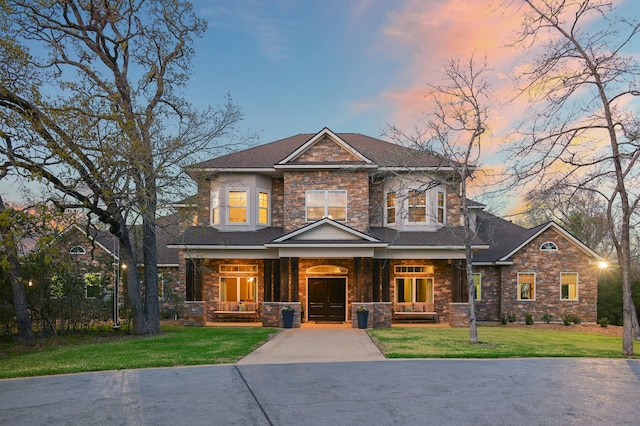 craftsman house with covered porch and a lawn