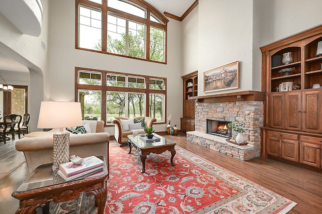 living room with a wealth of natural light, dark wood-type flooring, and a high ceiling