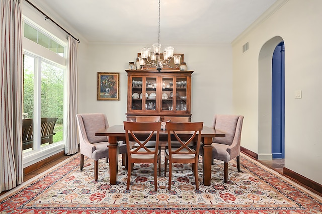 dining area featuring crown molding, an inviting chandelier, and plenty of natural light