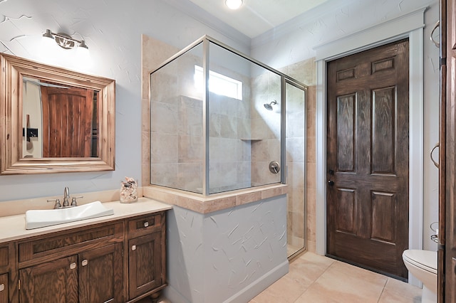 bathroom with vanity, toilet, tile patterned floors, and a shower with shower door