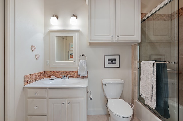 full bathroom with vanity, bath / shower combo with glass door, toilet, and tile patterned floors