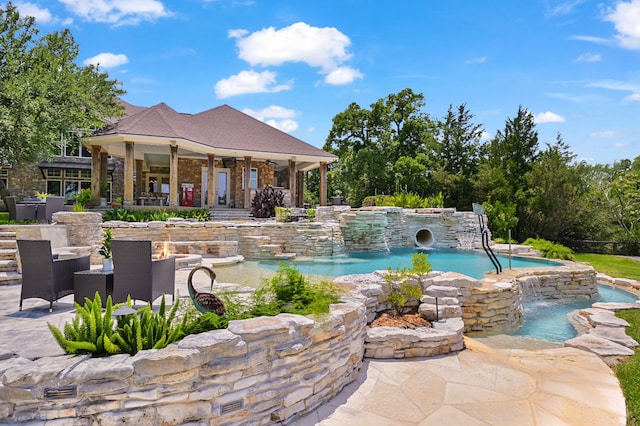 view of swimming pool featuring a hot tub, pool water feature, a patio, and ceiling fan