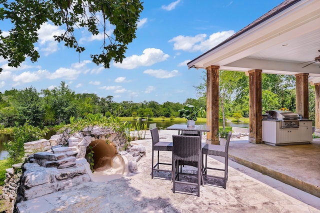 view of patio / terrace featuring a water view, ceiling fan, and a grill