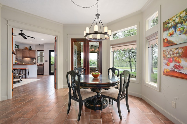 dining space featuring tile patterned floors, ornamental molding, and ceiling fan with notable chandelier