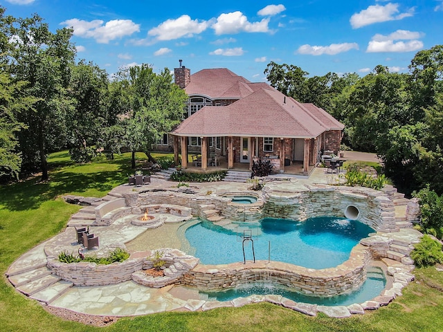 view of swimming pool with an in ground hot tub, a patio, and a lawn