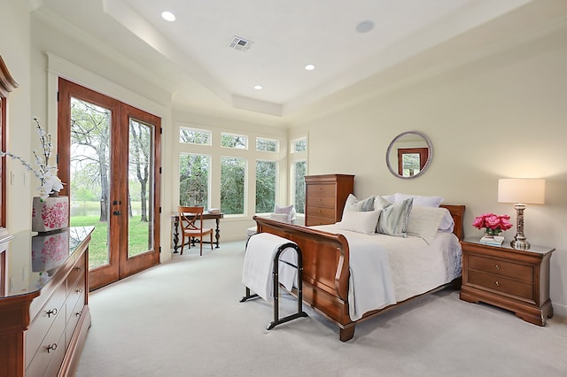 bedroom featuring french doors, a tray ceiling, access to exterior, ornamental molding, and light colored carpet