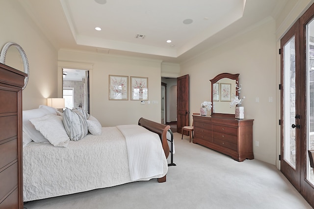 bedroom with light carpet, access to exterior, and a raised ceiling