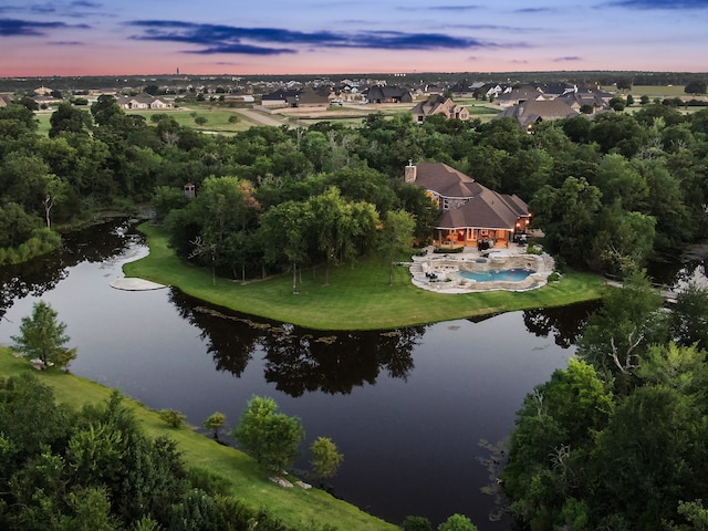 aerial view at dusk featuring a water view