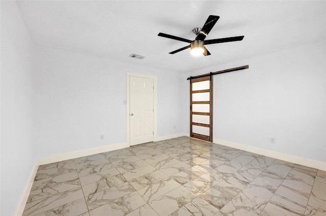 unfurnished room with a barn door and ceiling fan