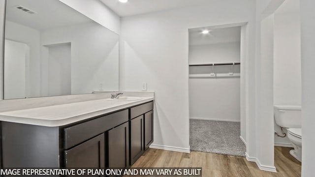 bathroom with vanity, hardwood / wood-style floors, and toilet