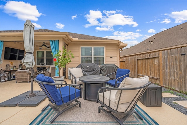 view of patio / terrace with ceiling fan and an outdoor living space with a fire pit