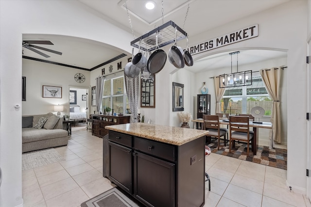 kitchen featuring a kitchen island, ornamental molding, light tile patterned floors, and ceiling fan