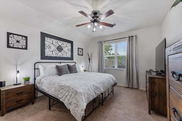 bedroom with light carpet, vaulted ceiling, and ceiling fan