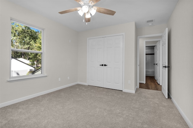 unfurnished bedroom with light colored carpet, ceiling fan, and a closet