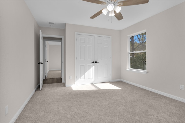 unfurnished bedroom with a closet, light carpet, and ceiling fan